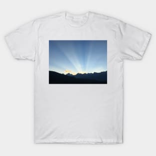 Sun peeking behind the mountains at sunset T-Shirt